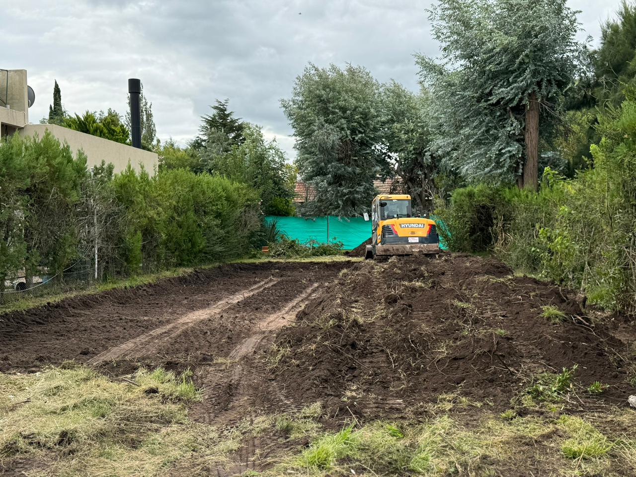 Retroexcavadora preparando terreno en obra de movimiento de suelos